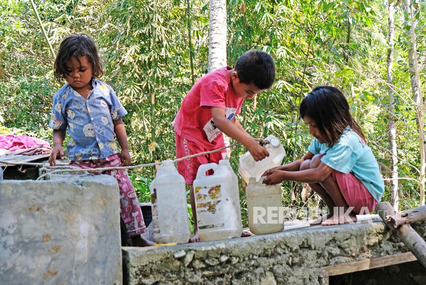 Sejumlah anak membantu orang tuanya mengumpulkan air bersih menggunakan jerigen di bak penampungan di kampung adat Prai Ijing, Desa Tebara, Waikabubak, Sumba Barat, Nusa Tenggara Timur.