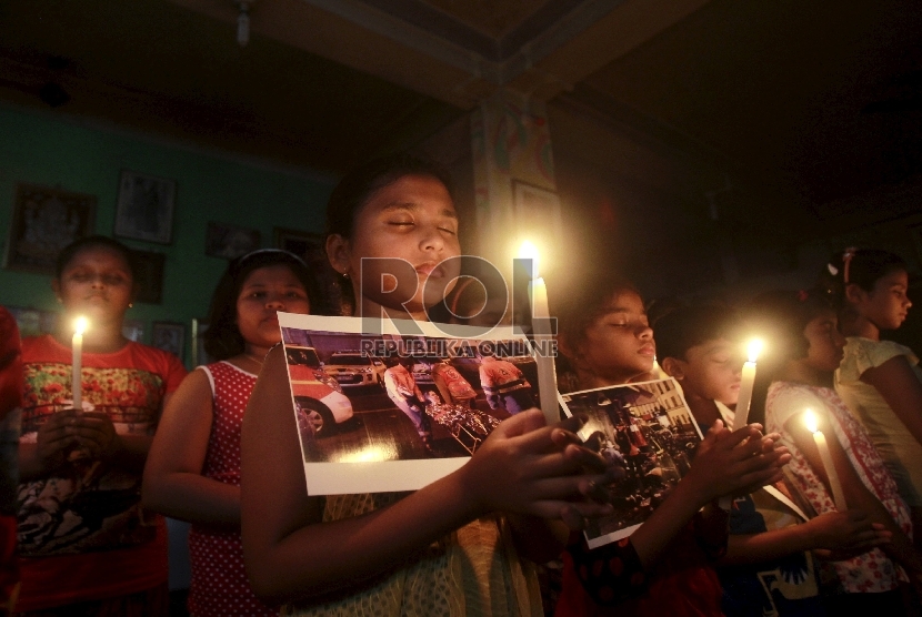 Sejumlah anak memegang lilin untuk menunjukkan solidaritas bagi para korban serangan Paris, di sebuah sekolah tari di Agartala, India, Sabtu (14/11). REUTERS / Jayanta Dey