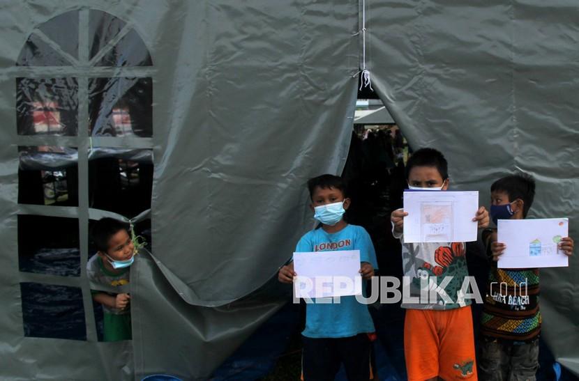 Sejumlah anak memperlihatkan gambar saat mengikuti pembelajaran di tenda pengungsian Stadion Manakarra, Mamuju, Sulawesi Barat, Sabtu (23/1/2021). Relawan memberikan kegiatan yang mendidik dan menghibur anak-anak korban gempa untuk menghilangkan trauma.