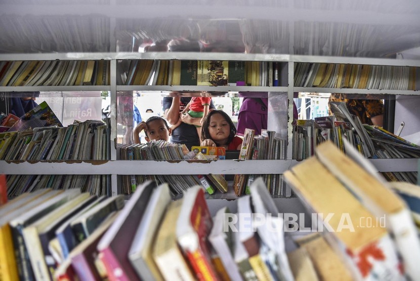 Sejumlah anak mencari buku di perpustakaan keliling. Saat ini perpustakaan memiliki 25 ribu eksemplar dari 11 ribu judul dan 2.500 e-book. Ilustrasi.