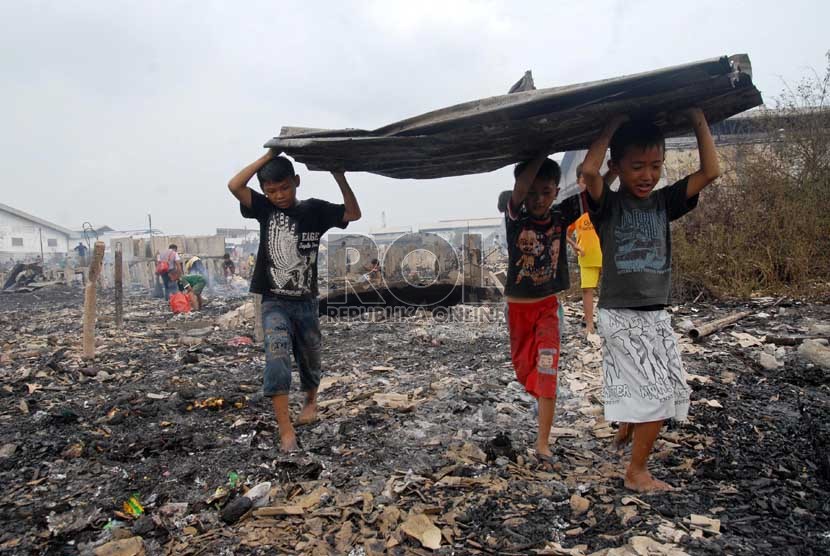  Sejumlah anak mengangkut barang yang tersisa dari kebakaran yang melanda pemukiman semi permanen di Jalan Kapuk Raya, Kapuk, Jakarta Utara, Selasa (11/12).  (Republika/Agung Fatma Putra)