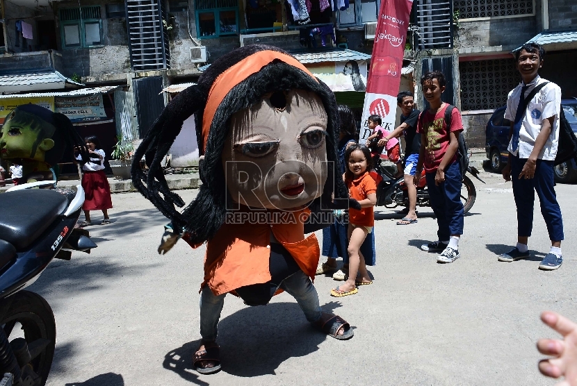 Sejumlah anak menonton boneka yang mengamen di Jalan Tambora, Jakarta Barat, Senin (9/3).  Polisi meringkus pengamen yang melakukan perampasan ponsel dan sekaligus mencekik Aldy (ilustrasi).