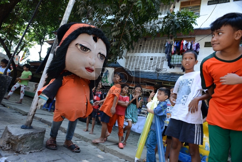 Sejumlah anak menonton pengamen boneka yang mengamen di Jalan Tambora, Jakarta Barat, Senin (9/3).   (Republika/Raisan Al Farisi)