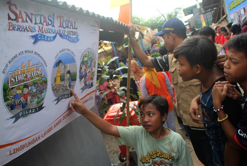 Sejumlah anak menyaksikan poster kebersihan pada saat Deklarasi Stop Buang Air Besar Sembarangan di Kelurahan Semper Barat, Kecamatan Cilincing, Jakarta Utara, Rabu (16/3). 