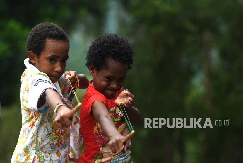 Sejumlah anak pengungsi banjir bandang Sentani bermain karet di halaman Kantor Bupati Jayapura yang dijadikan tempat pengungsian di Sentani, Jayapura, Papua, Kamis (21/3/2019).
