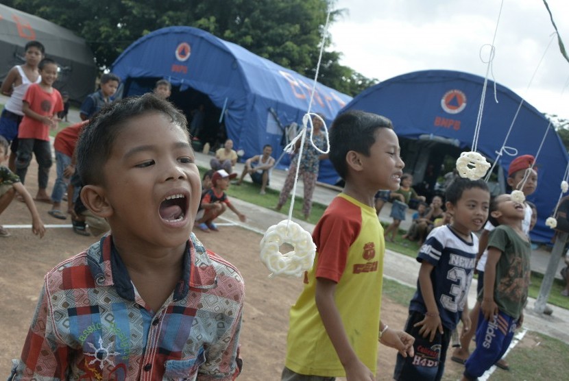 Sejumlah anak pengungsi Gunung Agung mengikuti lomba permainan tradisional di posko pengungsian GOR Swecapura, Klungkung, Bali, Minggu (15/10).