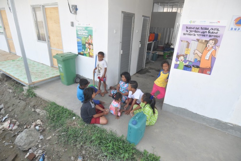 Sejumlah anak pengungsi korban bencana gempa dan likuifaksi bermain di sekitar kamar mandi umum di Hunian Sementara (Huntara) Petobo, Palu, Sulawesi Tengah, Senin (15/4/2019).