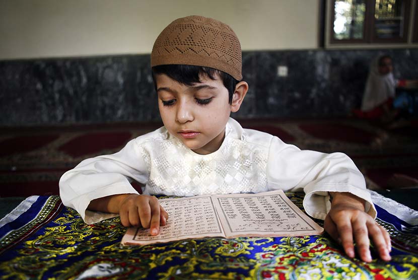  Sejumlah anak tengah membaca kitab suci Alquran di sebuah masjid di kota Herat, Afghanistan.  (EPA/Jalil Rezayee)