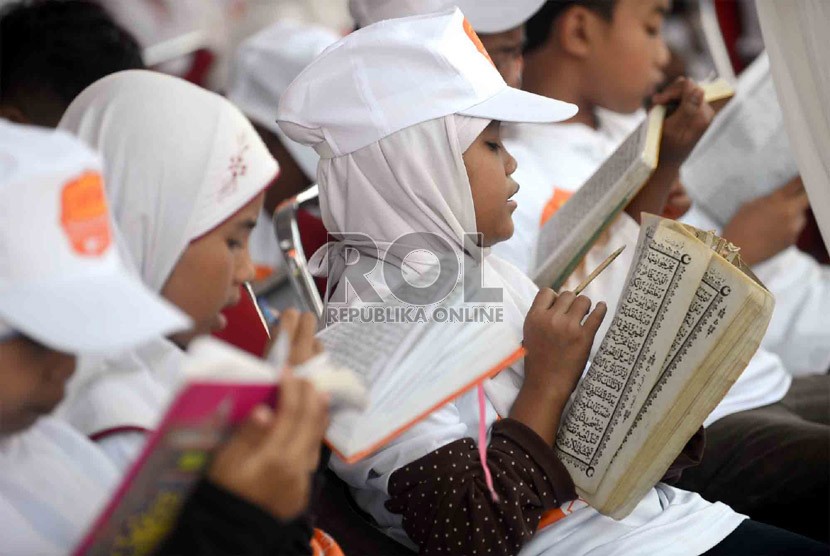  Sejumlah anak yatim mengikuti Khataman Alquran yang diadakan oleh Rumah Zakat di Monumen Nasional (Monas) Jakarta, Ahad (7/7).  (Republika/Agung Supriyanto)