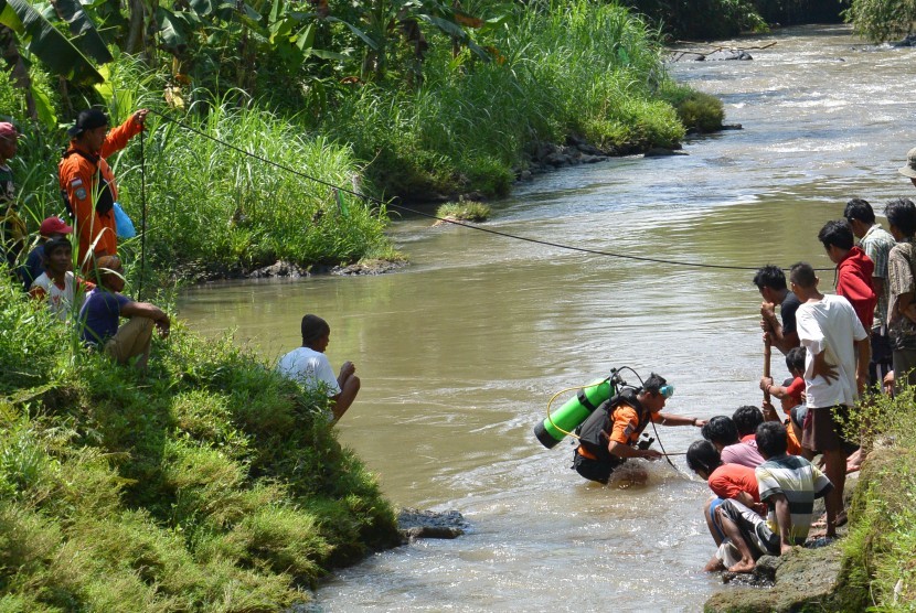 Sejumlah anggota Badan SAR Nasional (Basarnas) melakukan pencarian seorang relawan Badan Penanggulangan Bencana Daerah (BPBD) yang hilang dengan cara menyelam di Sungai Suren, Desa Pakusari, Jember, Jawa Timur, Kamis (24/11).