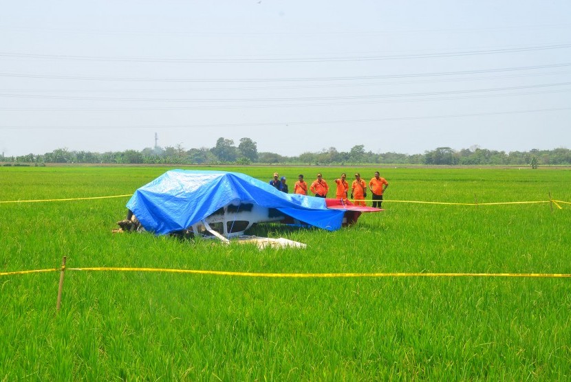 Sejumlah anggota Basarnas melihat pesawat jenis Cesna 172 yang jatuh di areal sawah Desa Banjar Wangunan, Mundu, Cirebon, Jawa Barat, Selasa (30/8).