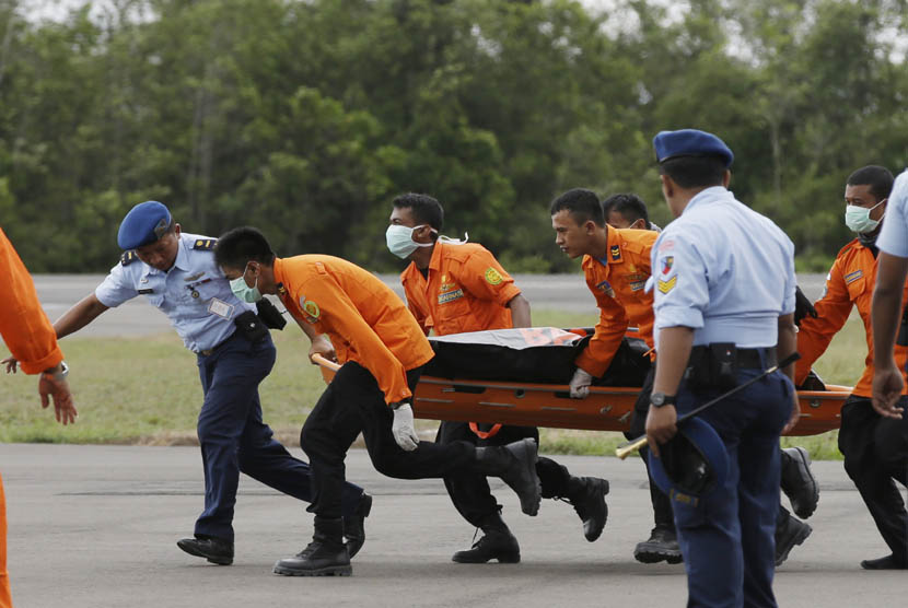   Sejumlah anggota Basarnas mengevakuasi jenazah korban jatuhnya pesawat AirAsia QZ8501, di Lanud TNI AU Iskandar Pangkalan Bun, Kalteng, Rabu (31/12).  (AP/Achmad Ibrahim)
