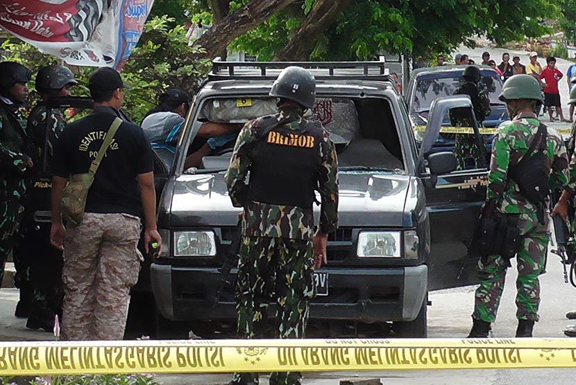 Sejumlah anggota Brimob berjaga disekitar mobil ketika olah tempat kejadian perkara (TKP) baku tembak antara Polisi dengan kelompok sipil bersenjata  di Sanginora, Poso Pesisir, Sulawesi Tengah, Selasa (9/2). 