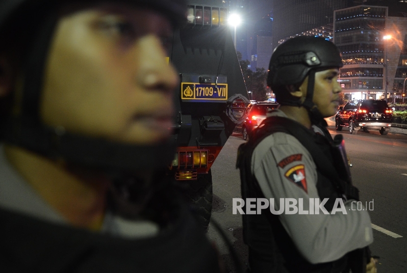 Sejumlah anggota Brimob bersenjata lengkap sedang berjaga-jaga.