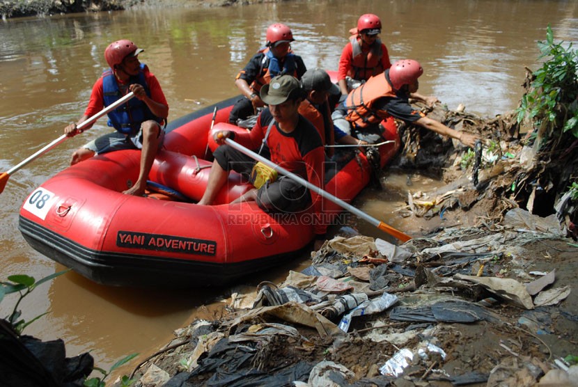   Sejumlah anggota dan masyarakat peduli Ciliwung menaiki perahu karet untuk memunguti sampah di bantaran Kali Ciliwung. Ilustrasi