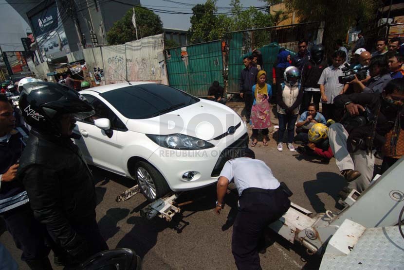 Sejumlah Anggota dari Dinas Perhubungan melakukan razia kepada pengendara mobil yang parkir sembarangan di kawasan Pondok Labu, Jakarta Selatan, Selasa (23/9).(Republika/Raisan Al Farisi)
