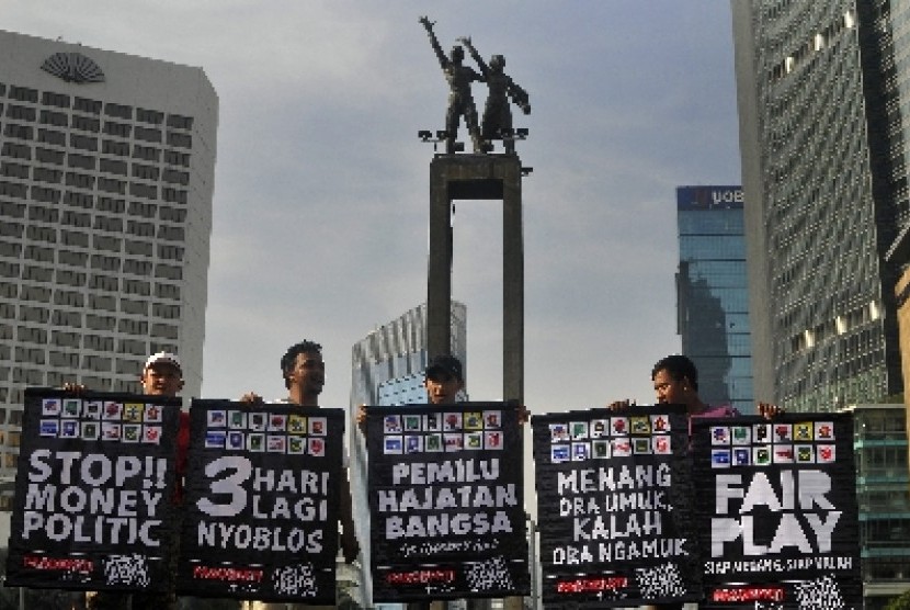Sejumlah anggota dari Republik Aeng-aeng dan Pasoepati memegang poster bertemakan pemilu damai saat aksi kampanye damai di Bundaran HI, Jakarta, Ahad (6/4).