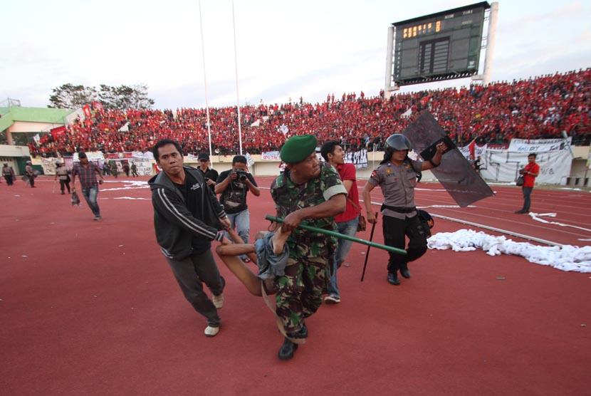    Sejumlah anggota Kepolisian dan TNI, mengevakuasi suporter dalam pertandingan antara tuan rumah Persis Solo melawan PSS Sleman, dalam lanjutan Divisi Utama LPIS di Stadion Manahan, Solo, Jateng, Rabu (4/9).      (Antara/Akbar Nugroho Gumay)