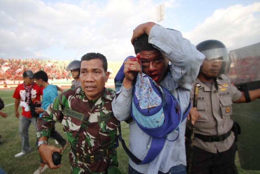  Sejumlah anggota Kepolisian dan TNI, mengevakuasi suporter yang terluka dalam pertandingan antara tuan rumah Persis Solo melawan PSS Sleman, dalam lanjutan Divisi Utama LPIS di Stadion Manahan, Solo, Jateng, Rabu (4/9).      (Antara/Akbar Nugroho Gumay)  