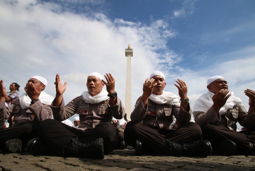 Sejumlah anggota kepolisian yang sekaligus pasukan Asmaul Husna berdoa saat mengikuti apel gelar pasukan pengamanan aksi bela Islam jilid III (212) di Monas, Jakarta, Kamis (1/12). 