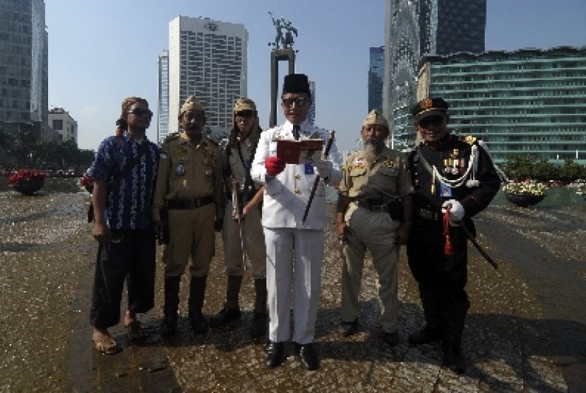  Sejumlah anggota komunitas ontel Taman MIni mengenakan kostum Bung Karno dan prajurit membacakan teks proklamasi saat hari bebas kendaraan bermotor di bundaran HI, Jakarta,