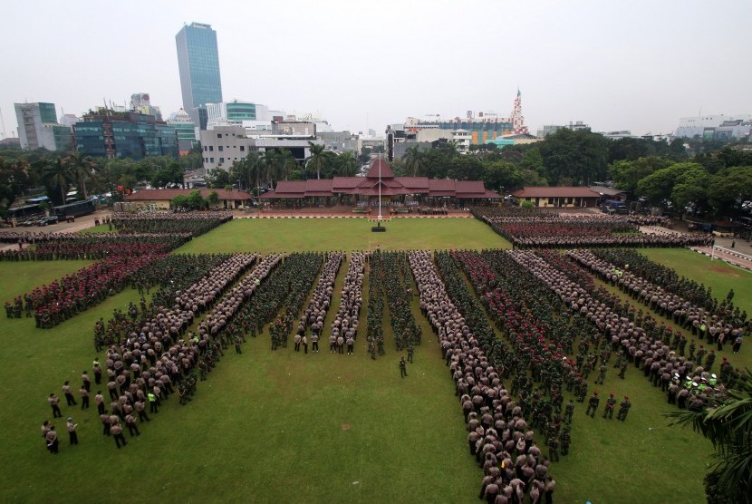 Sejumlah anggota Polri dan prajurit TNI mengikuti apel gabungan pergeseran pasukan di Lapangan Bhayangkara, Jakarta, Selasa (18/4). Sebanyak 62 ribu personel gabungan TNI-Polri dikerahkan untuk pengamanan pelaksanaan Pilkada DKI Jakarta putaran kedua. 