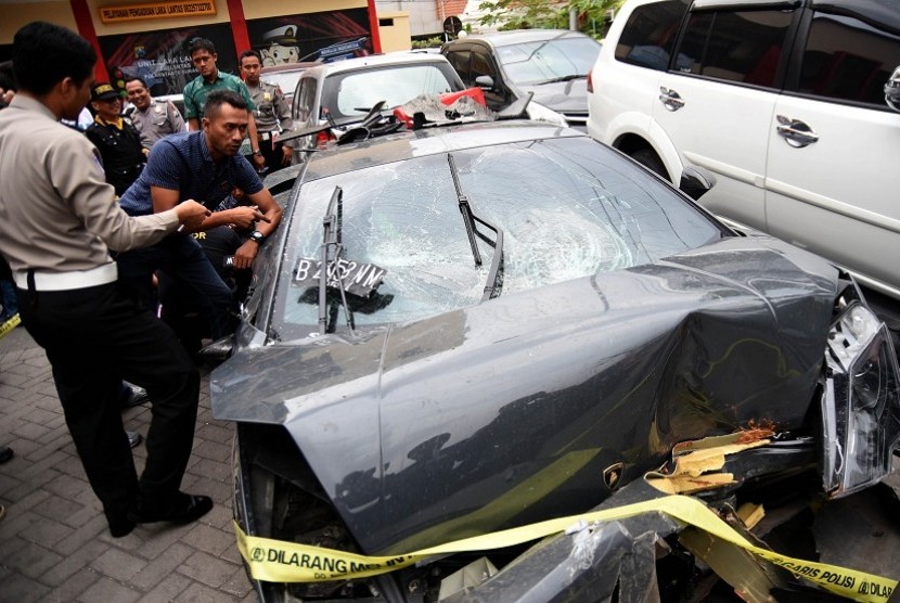 Sejumlah anggota Satlantas Polrestabes Surabaya mendampingi tim ahli dari perusahaan mobil Lamborghini mengamati barang bukti mobil yang terlibat kecelakaan di Kantor Unit Laka Lantas Polrestabes Surabaya, Jawa Timur, Jumat (4/12).