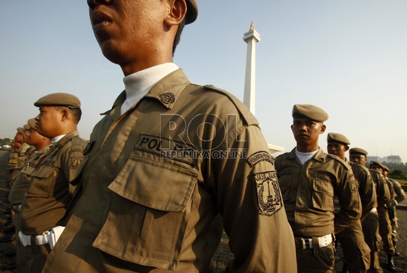  Sejumlah anggota Satpol PP berbaris mengikuti upacara peringatan HUT Satpol PP ke-63 dan satuan perlindungan Masyarakat ke-51 di Silang Monas, Jakarta, Selasa (30/4).  (Republika/Adhi Wicaksono)