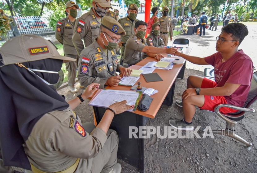 Sejumlah anggota Satpol PP mendata warga yang melanggar Perda karena tidak menggunakan masker di tempat umum saat razia di Mataram, NTB.