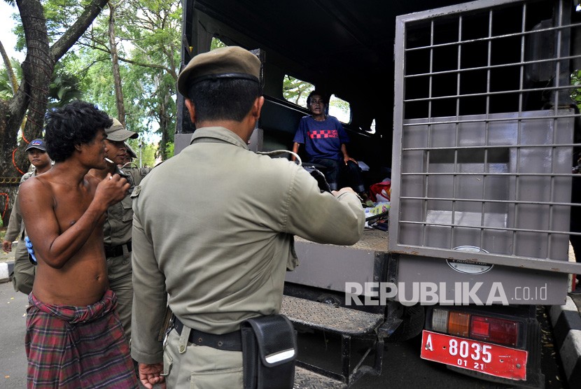 Sejumlah anggota Satpol PP Pemprov Banten mengamankan orang gila yang berkeliaran di Alun-alun Kota Serang, di Serang, Banten, Selasa (20/2). 