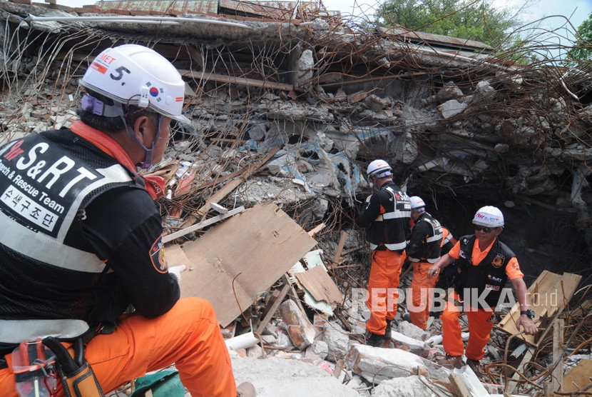 Sejumlah anggota Tim SAR Korea Selatan berusaha mengevakuasi korban gempa bumi yang tertimbun reruntuhan gedung Restoran Dunia Baru di Palu, Sulawesi Tengah, Senin (22/10/2018).