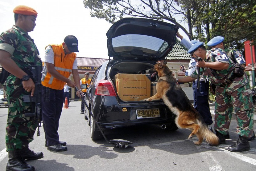 Sejumlah anggota TNI AU memeriksa mobil yang masuk menggunakan anjing pelacak bahan peledak di Bandara Adi Sutjipto Yogyakarta, Jumat (22/1). 