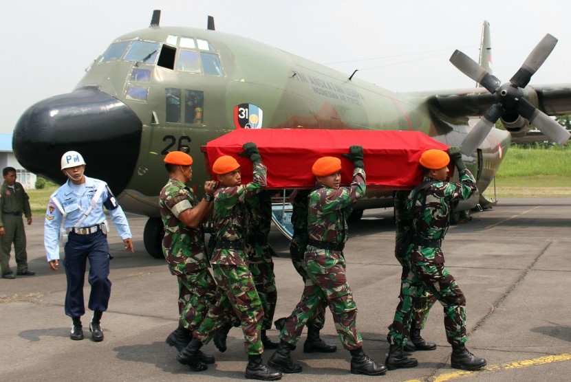 Sejumlah anggota TNI AU mengangkat peti yang berisikan jenasah dari korban pesawat pesawat Hercules C-130 saat proses pengembalian jenazah korban di Lanud Soewondo Medan, Sumatera Utara, Rabu (1/7).
