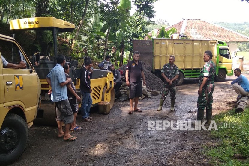 Sejumlah anggota TNI dan masyarakat tengah melakukan pengadaan material pengaspalan jalan yang merupakan bagian dari program Tentara Manunggal Membangun Desa (TMMD). 