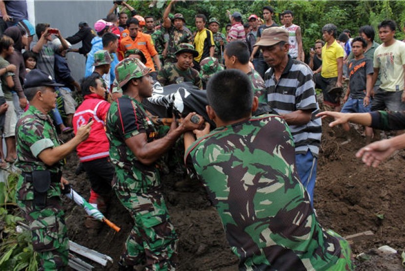  Sejumlah anggota TNI dibantu warga mengevakuasi korban tanah longsor di kawasan Citraland, kota Manado, Sulawesi Utara, Minggu (17/2). 