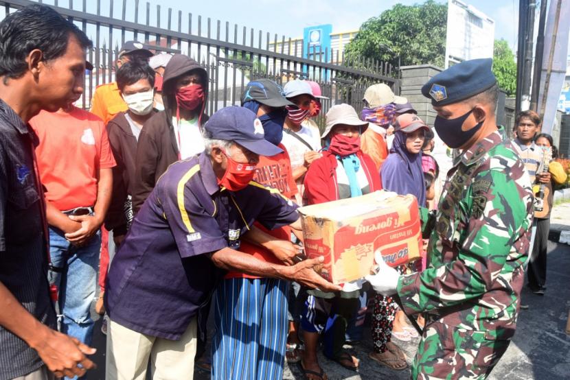 Sejumlah anggota TNI membagikan masker dan sembako ke warga terdampak Covid-19 di Kota Tasikmalaya, Senin (4/5). 