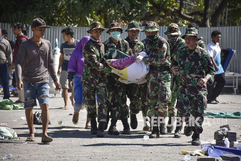Sejumlah anggota TNI mengangkat jenazah korban gempa bumi menuju mobil ambulans di halaman Rumah Sakit Umum Daerah Kabupaten Lombok Utara di Tanjung, Lombok Utara, NTB, Senin (6/8).