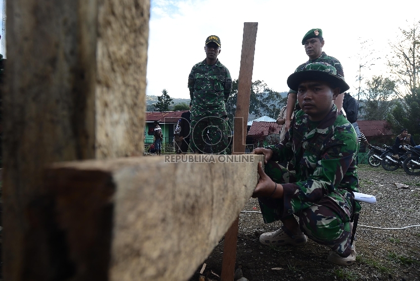 Sejumlah anggota TNI mengerjakan pembangunan pondasi untuk pembangunan Mushalla di Tolikara, Papua, Jumat (24/7).  (Republika/Raisan Al Farisi)