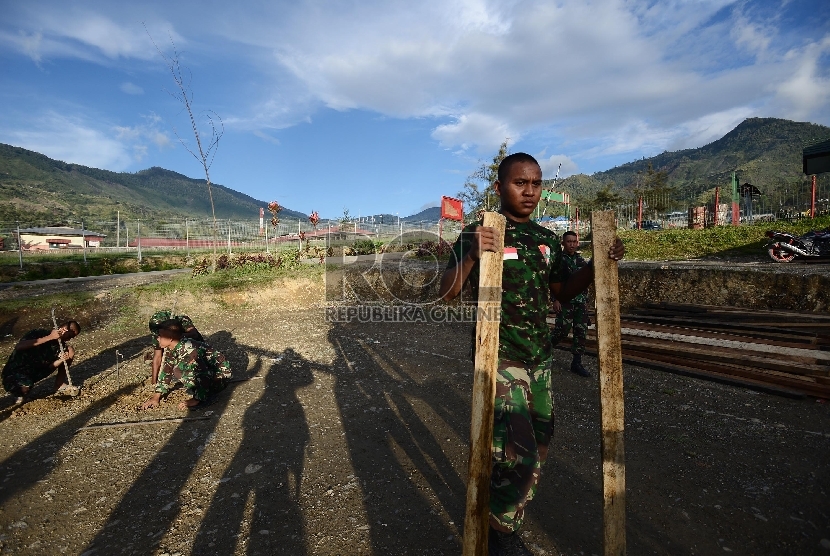 Sejumlah anggota TNI mengerjakan pembangunan pondasi untuk pembangunan Mushalla di Tolikara, Papua, Jumat (24/7).  (Republika/Raisan Al Farisi)
