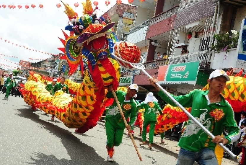 Sejumlah anggota Yayasan Tionghoa Pemadam Kebakaran Merdeka memainkan atraksi naga, sesaat sebelum menjalani ritual Naga Tutup Mata di Kelenteng Kwan Tie Bio, Pontianak, Kalbar