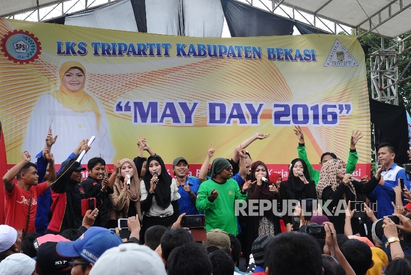 Sejumlah artis bernyanyi saat memperingati Hari Buruh Internasional di kawasan industri MM2100, Cibitung, Bekasi, Jawa Barat, Ahad (1/5). Peringatan diisi dengan siraman rohani dan hiburan panggung. 