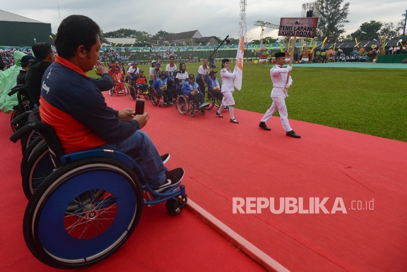   Sejumlah atlet tenis lapang kursi roda memasuki lapangan untuk mengikuti upacara penutupan Pekan Paralimpik Nasional (Peparnas) XV yang diadakan di Stadion Siliwangi, Kota Bandung, Jawa Barat, Senin (24/10).(Republika/Raisan Al Farisi)