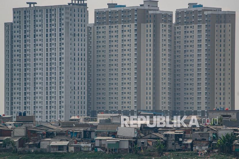 Sejumlah bangunan semi permanen hunian warga berdiri dengan latar belakang gedung-gedung apartemen di tepi Waduk Pluit, Penjaringan, Jakarta, Selasa (29/6/2021). Badan Pusat Statistik (BPS) mencatat penurunan tingkat ketimpangan pengeluaran penduduk di Indonesia menggunakan rasio gini adalah sebesar 0,381.