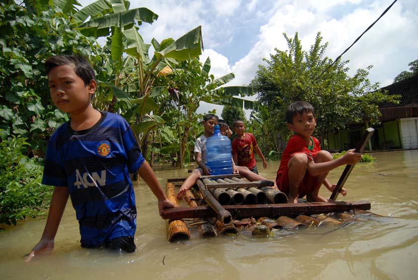  Sejumlah bocah membawa air mineral menggunakan rakit saat banjir menggenangi Desa Truni, Kecamatan Babat, Lamongan, Jawa Timur (Antara/Syaiful Arif)