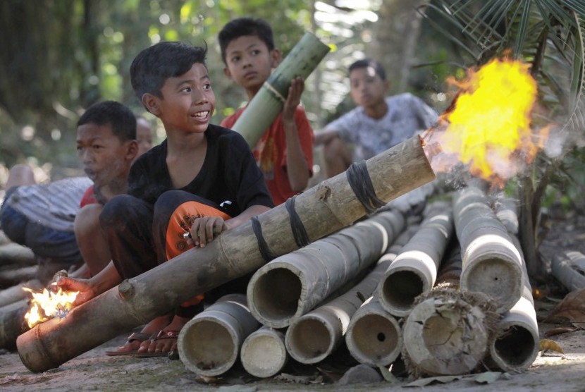 Sejumlah bocah menyalakan meriam bambu.
