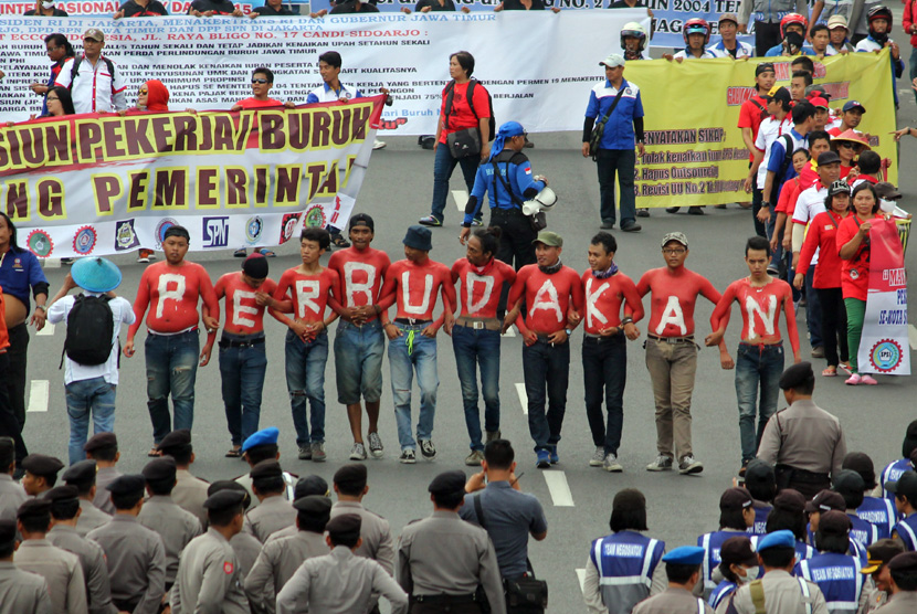 Sejumlah buruh dari Serikat Pekerja Nasional (SPN) berunjuk rasa di depan Gedung Negara Grahadi Surabaya, Jawa Timur, Kamis (30/4). (ANTARA/Didik Suhartono)