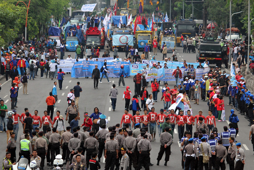 Sejumlah buruh dari Serikat Pekerja Nasional (SPN) berunjuk rasa di depan Gedung Negara Grahadi Surabaya, Jawa Timur, Kamis (30/4). (ANTARA/Didik Suhartono)