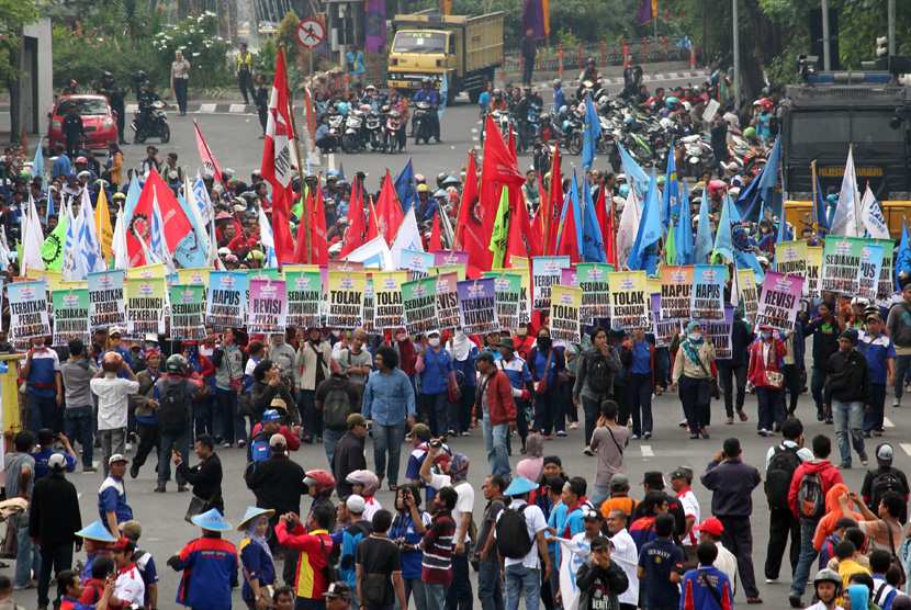 Sejumlah buruh dari Serikat Pekerja Nasional (SPN) berunjuk rasa di depan Gedung Negara Grahadi Surabaya, Jawa Timur, Kamis (30/4). (ANTARA/Didik Suhartono)