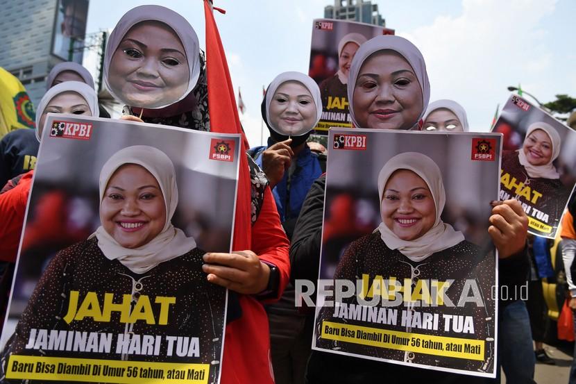 Sejumlah buruh mengenakan topeng Menteri Tenaga Kerja Ida Fauziah saat berunjuk rasa di depan Kantor Kementerian Ketenagakerjaan (Kemnaker), Jakarta, Rabu (16/2/2022). Presiden Jokowi telah meminta menaker merevisi Permenaker JHT.