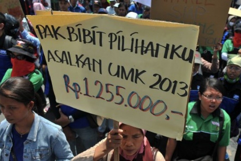Sejumlah buruh yang tergabung dalam Aliansi Gerakan Buruh Berjuang (Gerbang) membawa poster saat berunjuk rasa tentang usulan upah minimum kota (UMK), di Semarang, Jateng, Selasa (30/10).